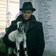 A man in a hat holds a small goat
